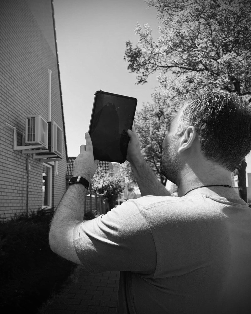 Floor Jansen fotografeert tijdens de opname een gevel met een tablet